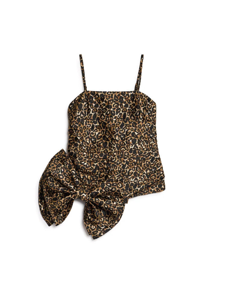 A leopard print top with thin spaghetti straps and a large knotted bow detail at the waist, shown flat on a white background.